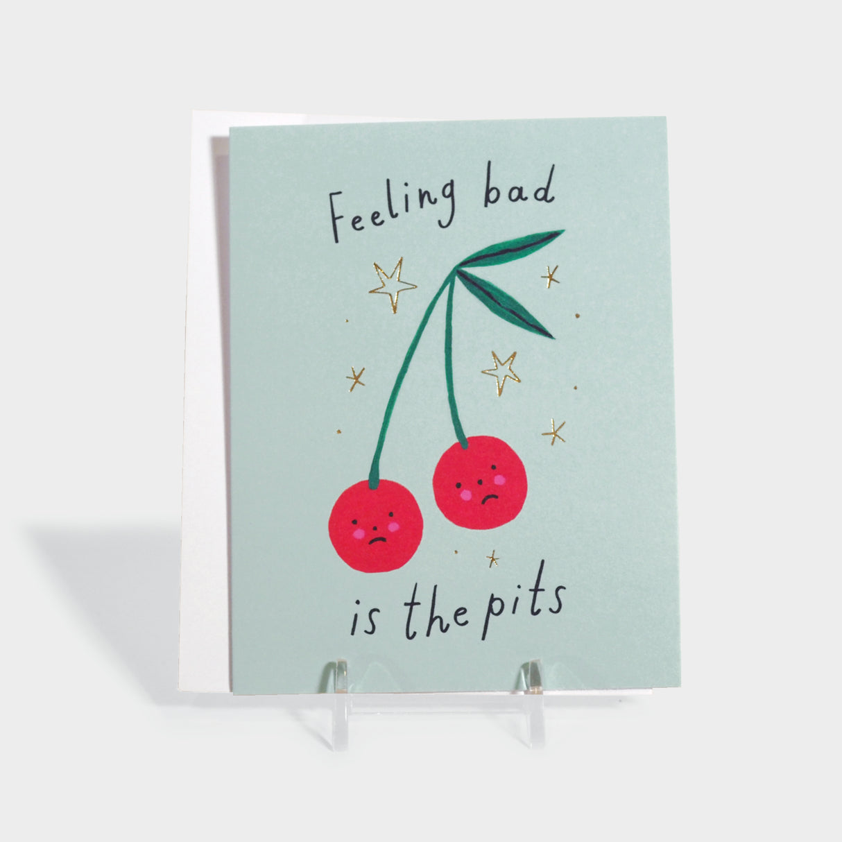 Greeting card with two sad cherries. Features gold foil-stamped details.