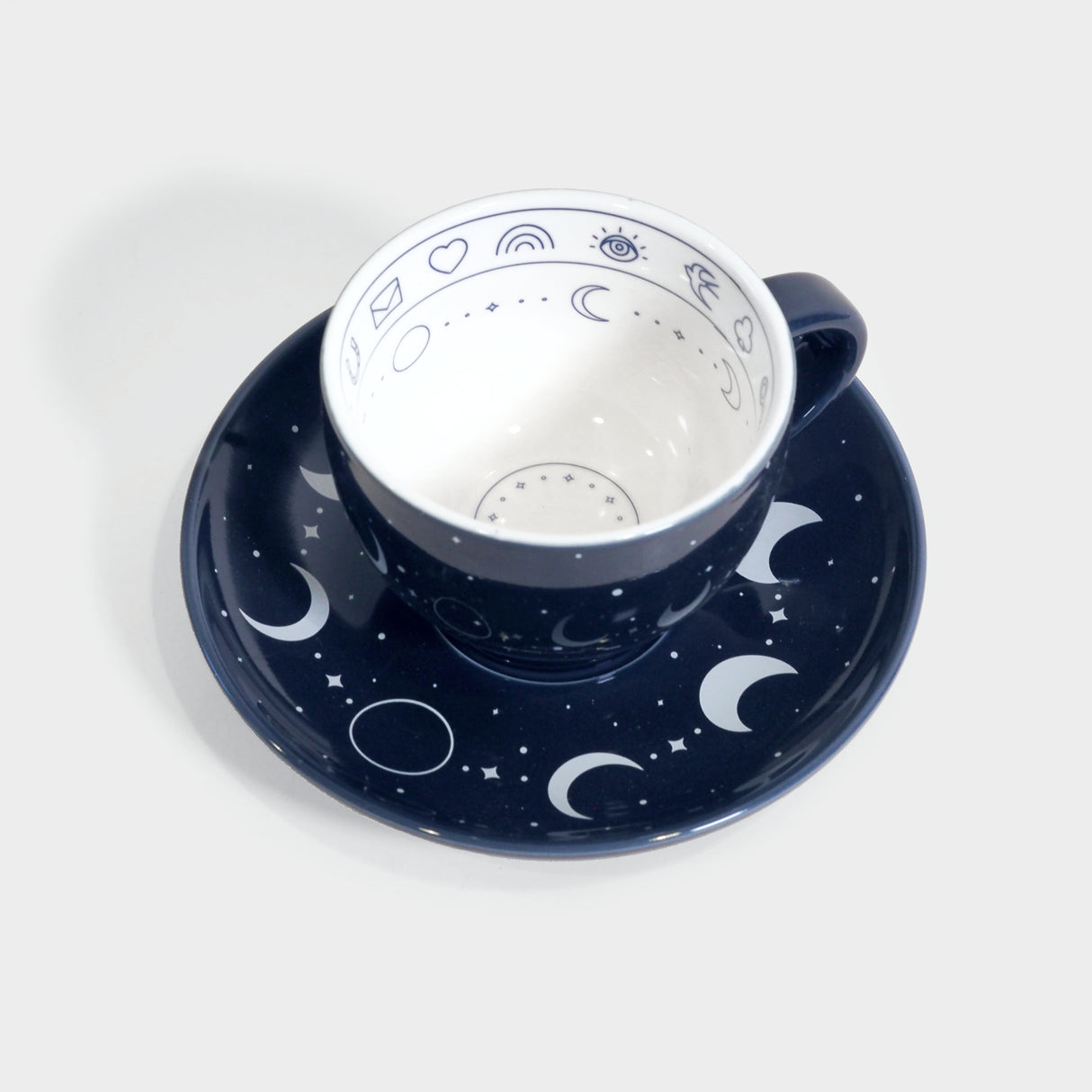 Phases of the moon themed blue and white tea cup and saucer.