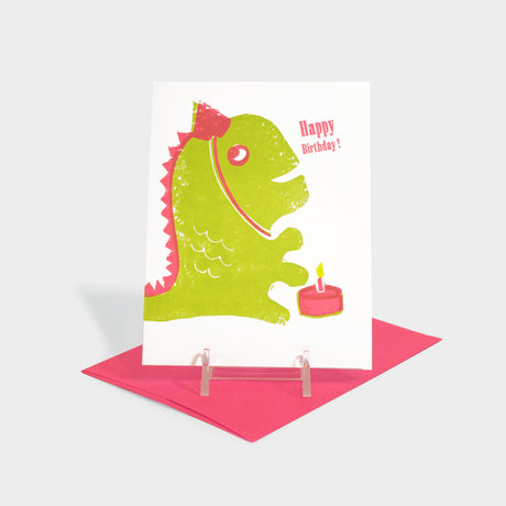 Greeting card with monster in a party hat and birthday cake illustration.