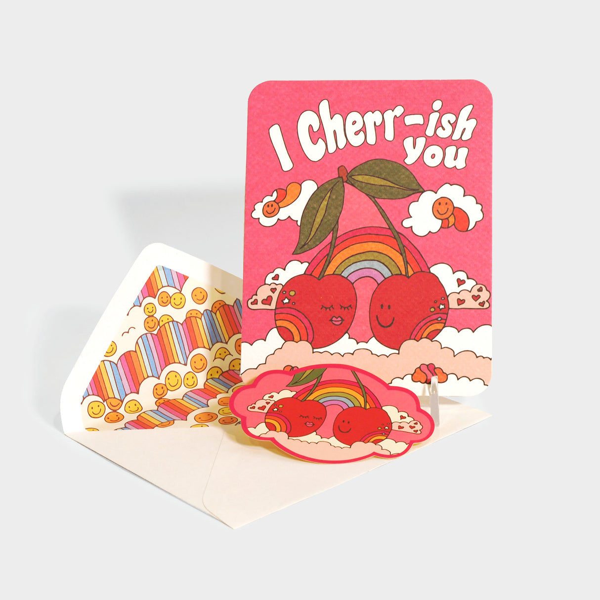 Greeting card with die-cut sticker. Features retro style illustrations of two cherries in the clouds.