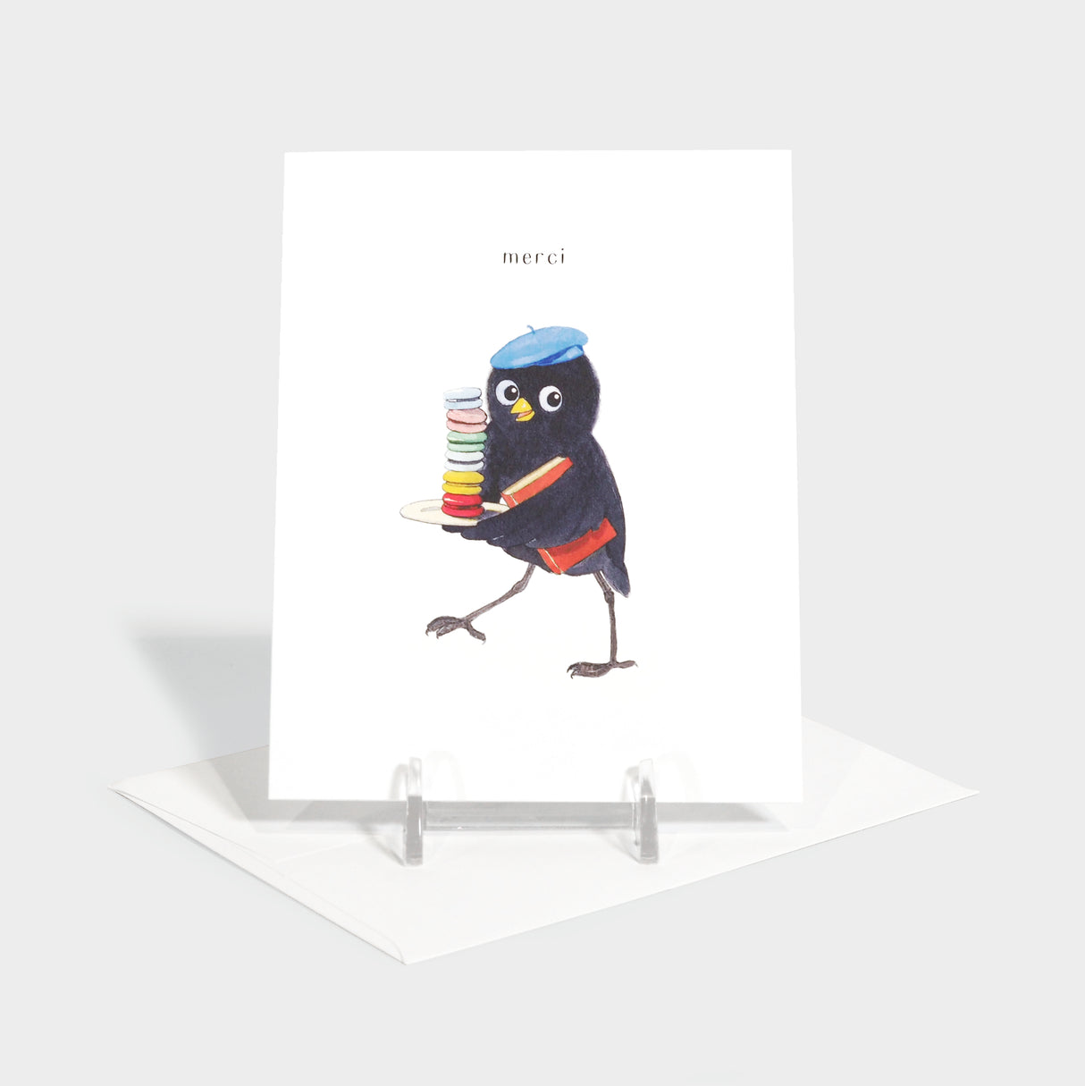 Greeting card with illustration of a bird in a beret holding a stack of macarons