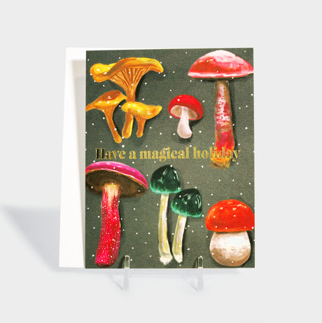 Greeting card with illustrated mushrooms and sprinkled snow. Features gold foil-stamped text.