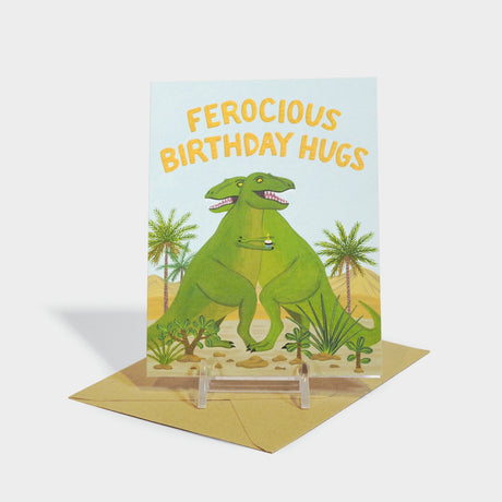 Greeting card with illustration of two dinosaurs hugging; one of them holds a cupcake.